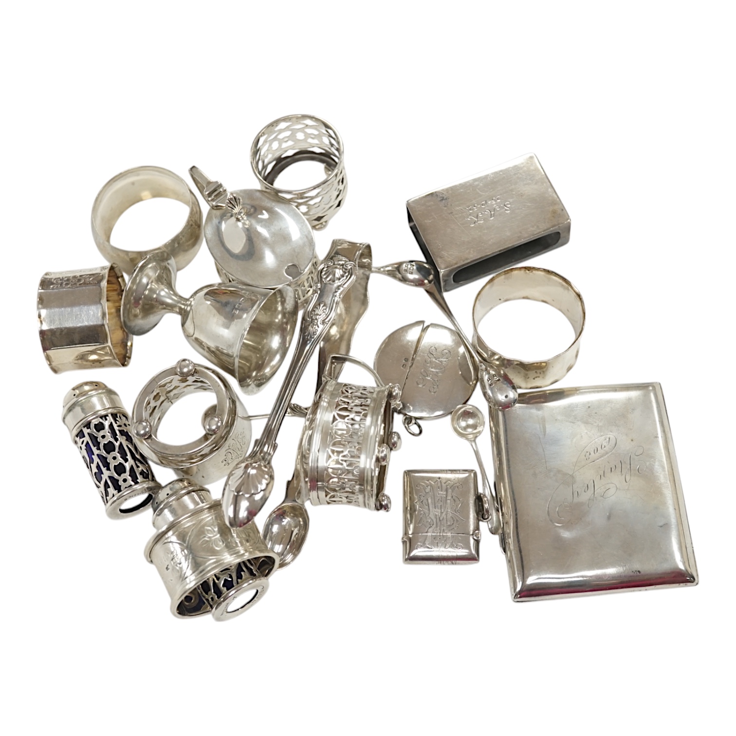 Assorted small silver ware including two vesta cases, cigarette case, matchbox sleeve, napkin rings, pair of sugar tongs and assorted condiments. some lacking liners. Condition - poor to fair